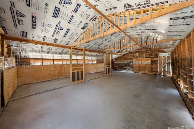 miscellaneous room with lofted ceiling and concrete floors