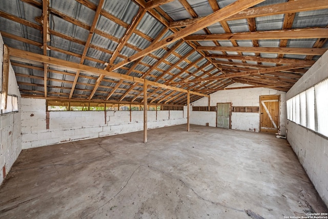 interior space with lofted ceiling and concrete flooring