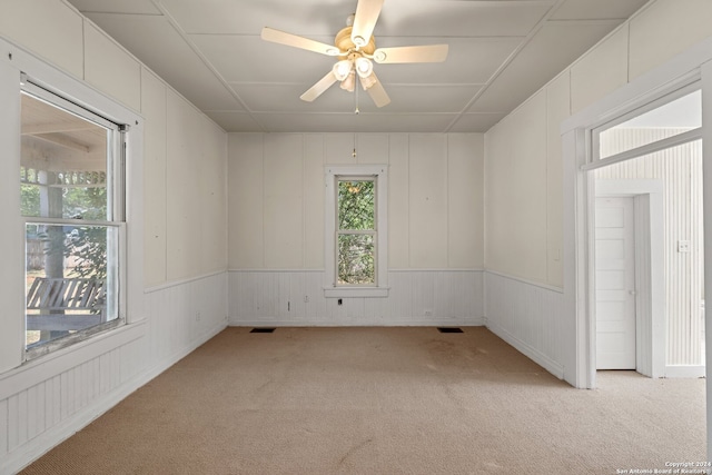 empty room featuring ceiling fan and light colored carpet