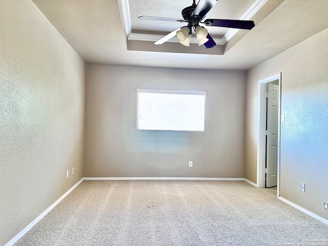 carpeted empty room featuring a textured ceiling, a tray ceiling, and ceiling fan