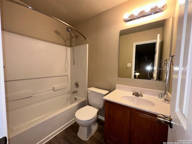 full bathroom featuring a textured ceiling, hardwood / wood-style floors, shower / bathing tub combination, vanity, and toilet