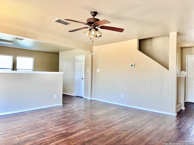 spare room with a textured ceiling, dark wood-type flooring, and ceiling fan