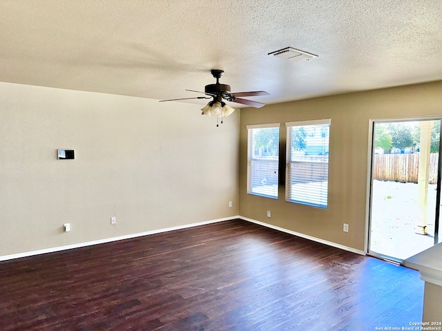 empty room featuring a textured ceiling, ceiling fan, and dark hardwood / wood-style flooring