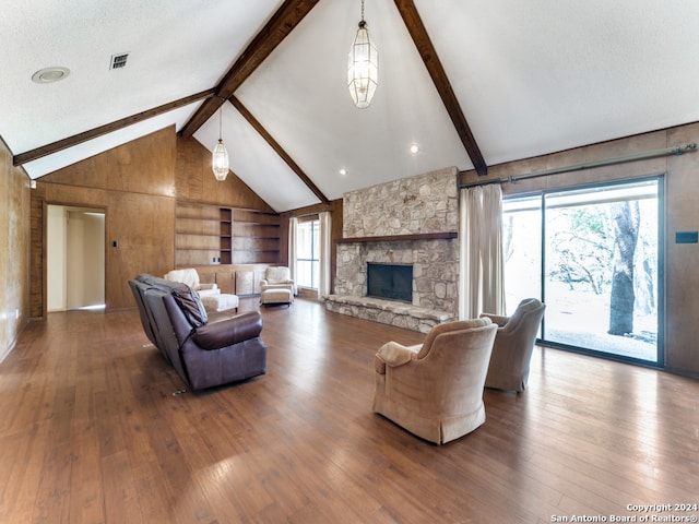 living room featuring a fireplace, hardwood / wood-style floors, high vaulted ceiling, beam ceiling, and a textured ceiling