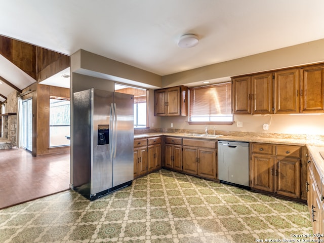 kitchen with appliances with stainless steel finishes, light hardwood / wood-style flooring, and sink