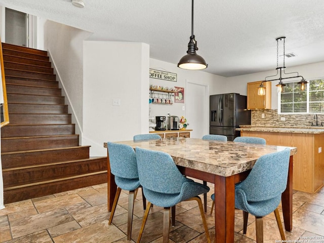 dining area with sink and a textured ceiling