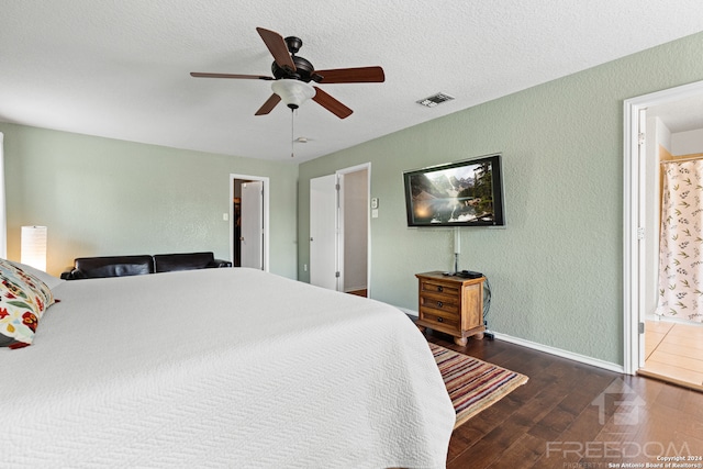 bedroom featuring a textured ceiling, ensuite bath, ceiling fan, and dark hardwood / wood-style floors