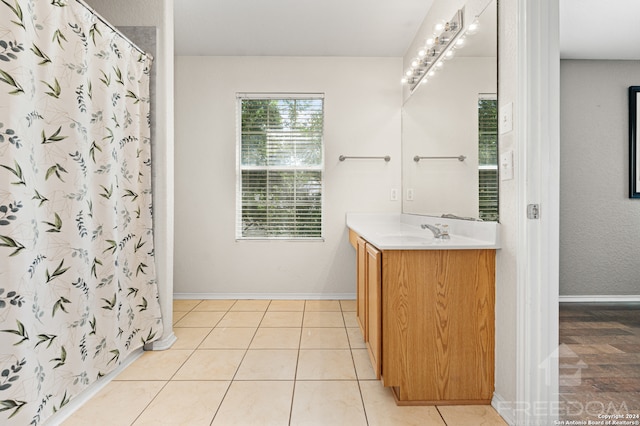 bathroom featuring tile patterned flooring, vanity, and walk in shower