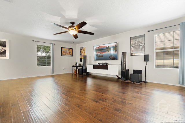 unfurnished living room with ceiling fan, dark wood-type flooring, and a textured ceiling