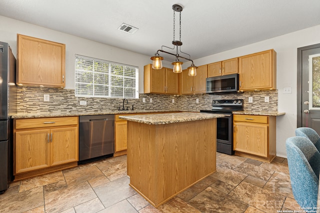 kitchen featuring a center island, light stone countertops, appliances with stainless steel finishes, tasteful backsplash, and decorative light fixtures