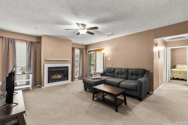 carpeted living room with a textured ceiling and ceiling fan