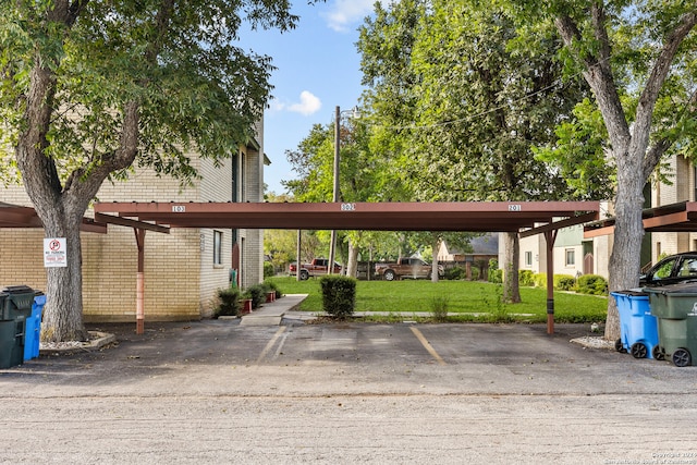 view of parking / parking lot with a lawn and a carport