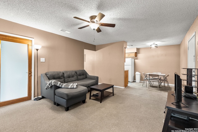 living room featuring light carpet, a textured ceiling, and ceiling fan