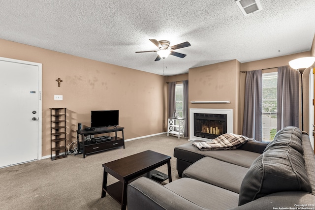 carpeted living room with ceiling fan and a textured ceiling