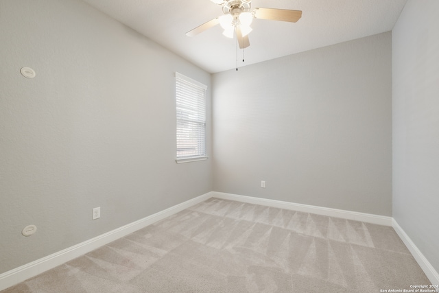 spare room with light colored carpet and ceiling fan