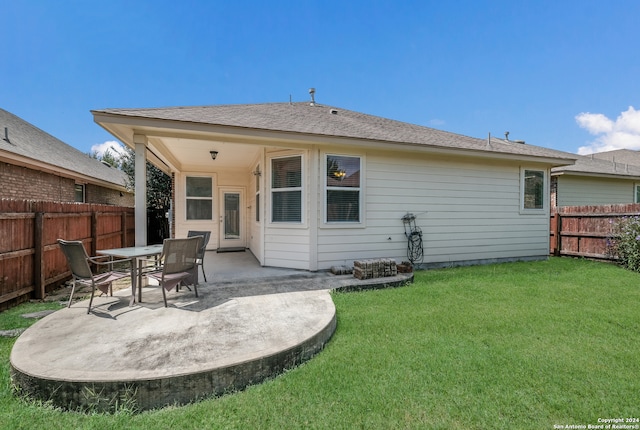 back of property with a lawn and a patio area