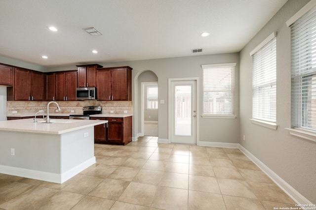 kitchen featuring a healthy amount of sunlight, backsplash, sink, and appliances with stainless steel finishes