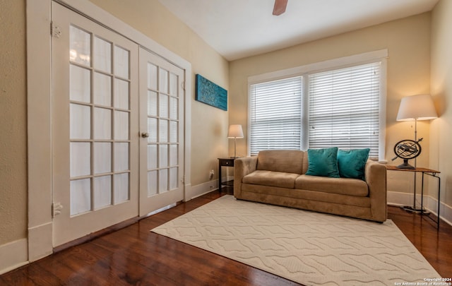 living room featuring ceiling fan and dark hardwood / wood-style flooring