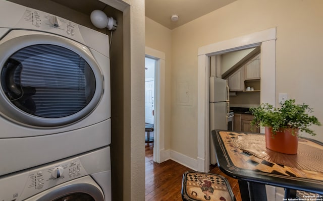 clothes washing area featuring stacked washer and dryer and dark hardwood / wood-style floors