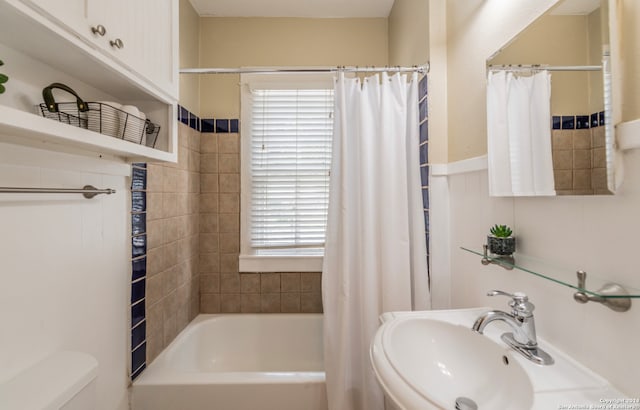 full bathroom with shower / bath combo with shower curtain, toilet, and sink