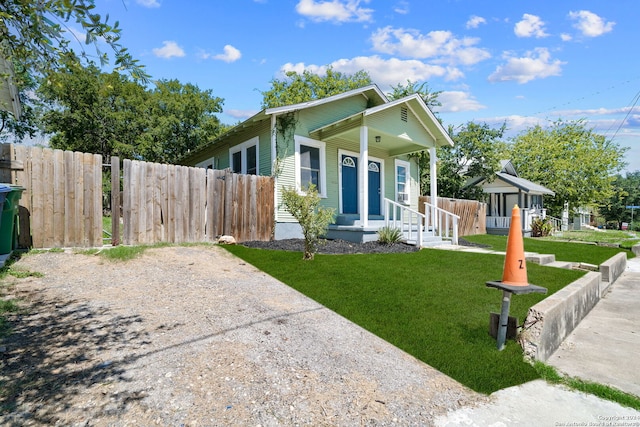 143 Paul St, San Antonio, TX 78203 - shotgun-style home featuring covered porch, a front yard, and fence