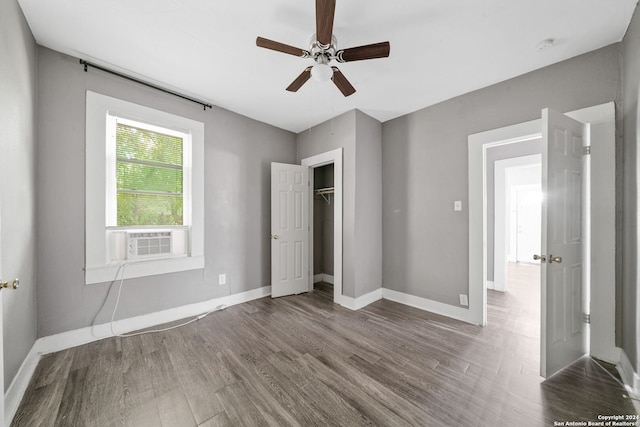 unfurnished bedroom with cooling unit, a closet, wood-type flooring, and ceiling fan