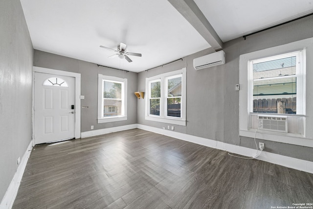 foyer entrance with dark wood-type flooring, a wall mounted AC, and ceiling fan