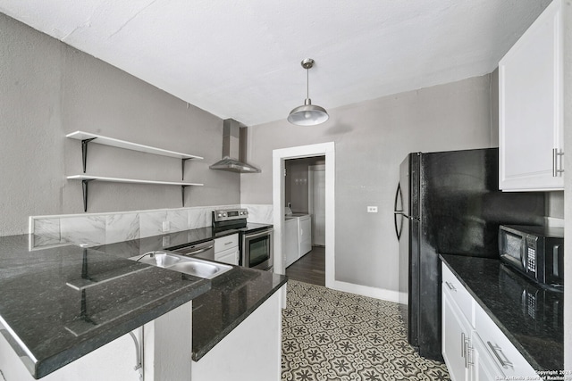 kitchen with white cabinetry, black appliances, washing machine and dryer, kitchen peninsula, and wall chimney range hood