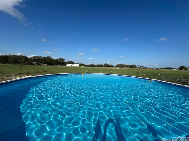 view of swimming pool with a yard