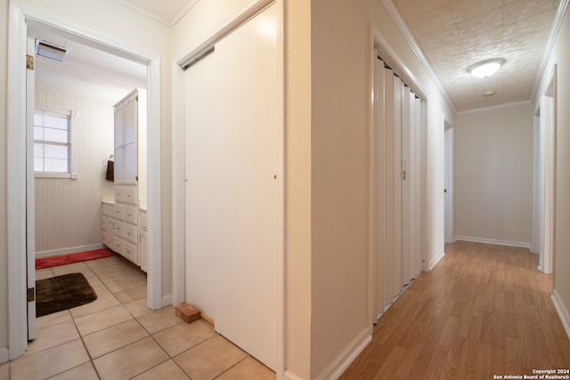 corridor featuring light wood-type flooring and ornamental molding