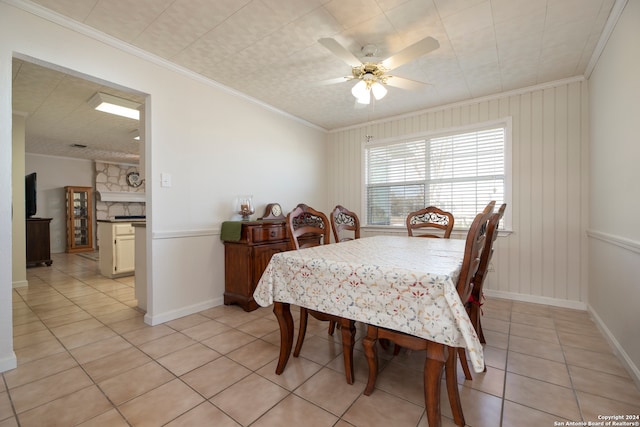 dining room with crown molding, light tile patterned flooring, and ceiling fan