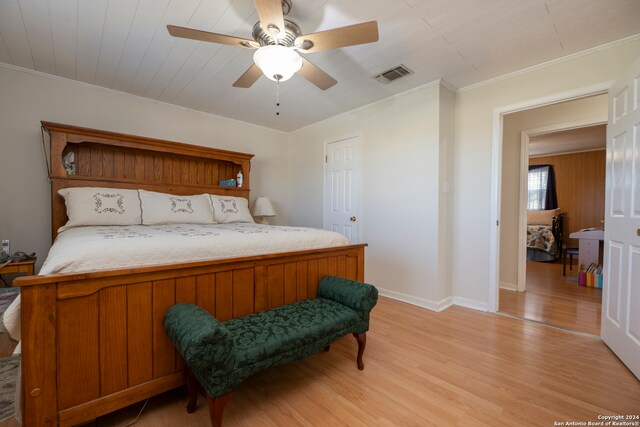 bedroom featuring ceiling fan, crown molding, and light hardwood / wood-style floors