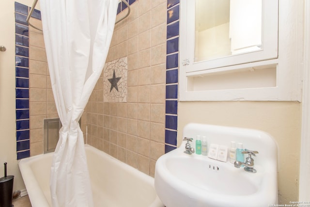 bathroom featuring shower / bath combination with curtain and sink