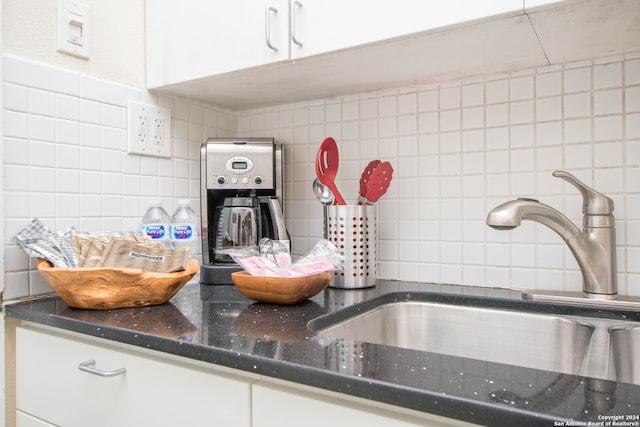 kitchen featuring white cabinetry, backsplash, and sink