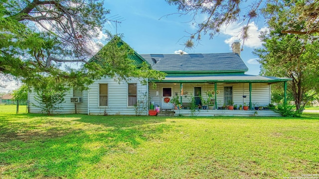 back of house with a lawn and covered porch