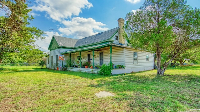 exterior space featuring covered porch and a yard