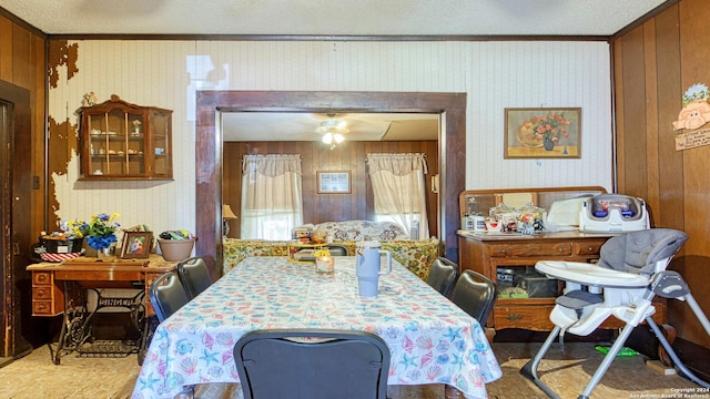 dining area with wooden walls and ornamental molding