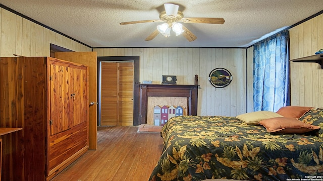 bedroom with ceiling fan, wooden walls, and light hardwood / wood-style floors