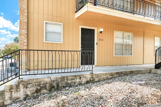 view of exterior entry featuring a balcony