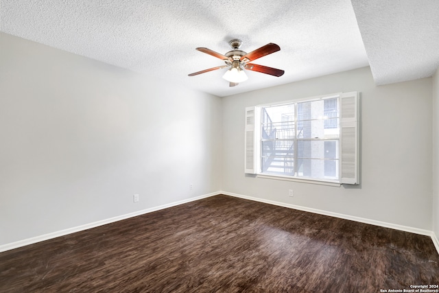 empty room featuring dark wood-type flooring, ceiling fan, and a textured ceiling