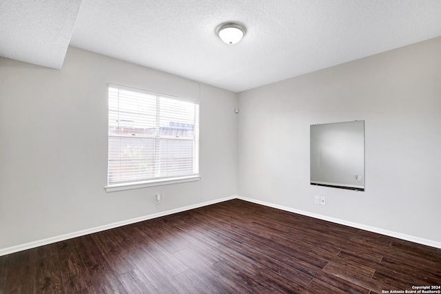 spare room featuring wood-type flooring and a textured ceiling