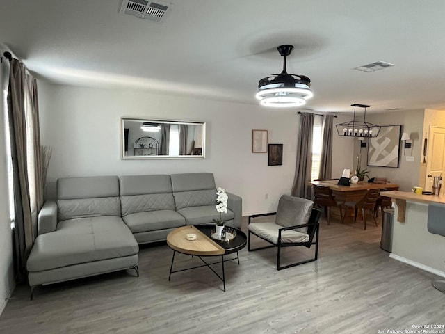 living room with light wood-type flooring and a chandelier