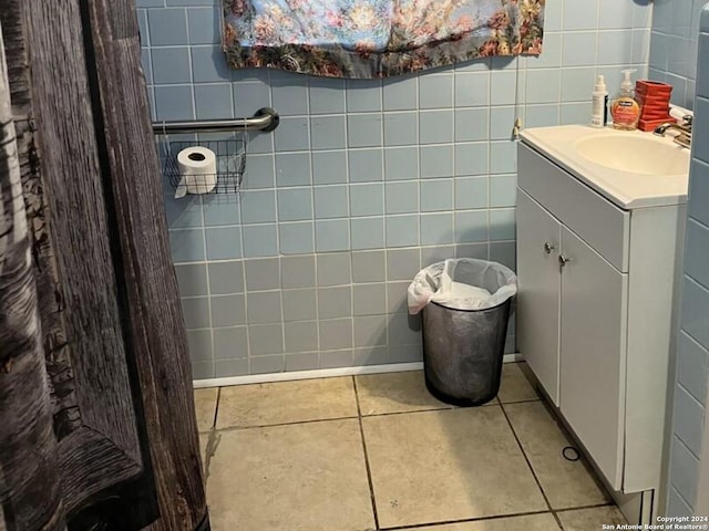 bathroom with tile walls, tile patterned flooring, and vanity