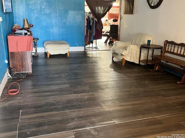 sitting room with baseboards and wood finished floors