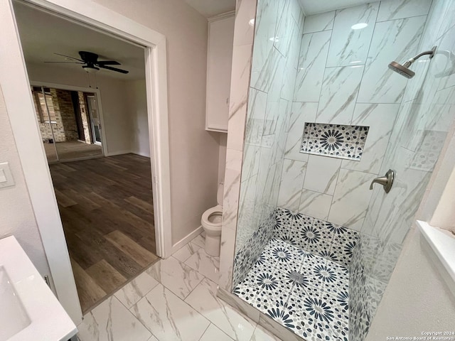 bathroom with tiled shower, ceiling fan, toilet, and hardwood / wood-style flooring