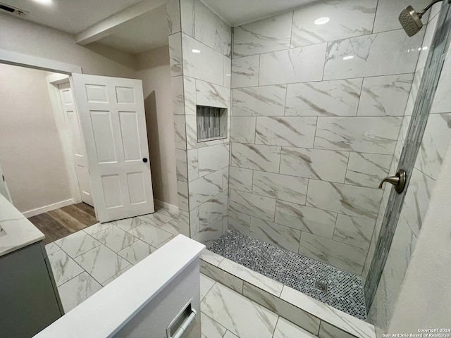 bathroom featuring tiled shower, vanity, and hardwood / wood-style flooring