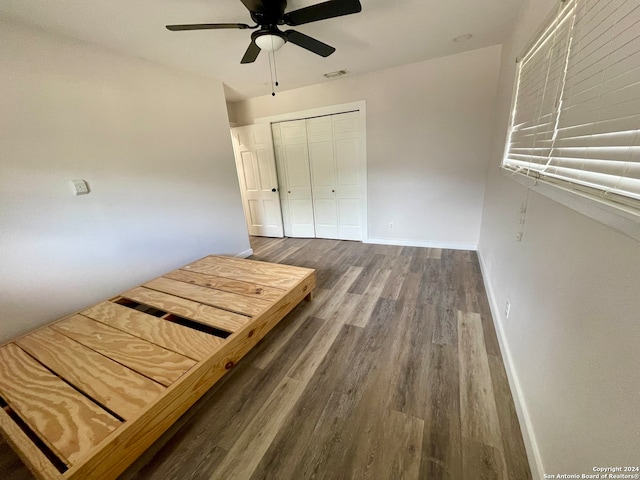 unfurnished bedroom featuring a closet, ceiling fan, and dark hardwood / wood-style flooring