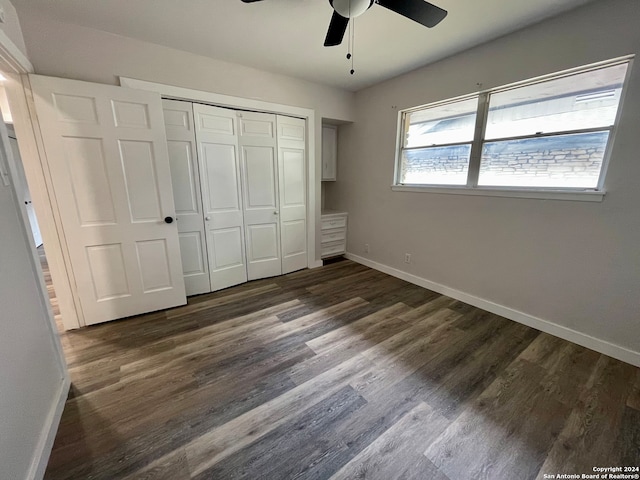 unfurnished bedroom featuring ceiling fan, a closet, and dark hardwood / wood-style flooring