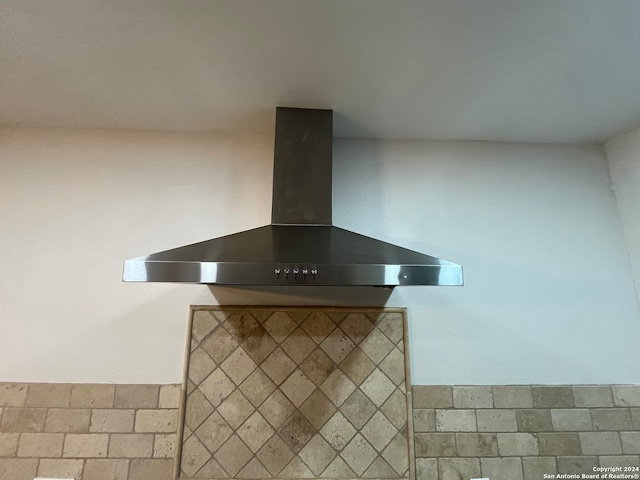 room details with wall chimney range hood