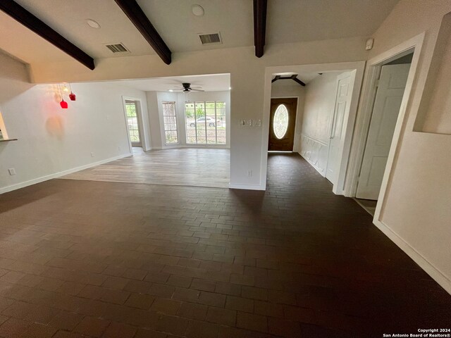 unfurnished living room featuring ceiling fan and beam ceiling